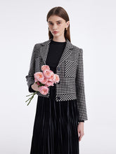 A lady wears a plaid crop jacket.